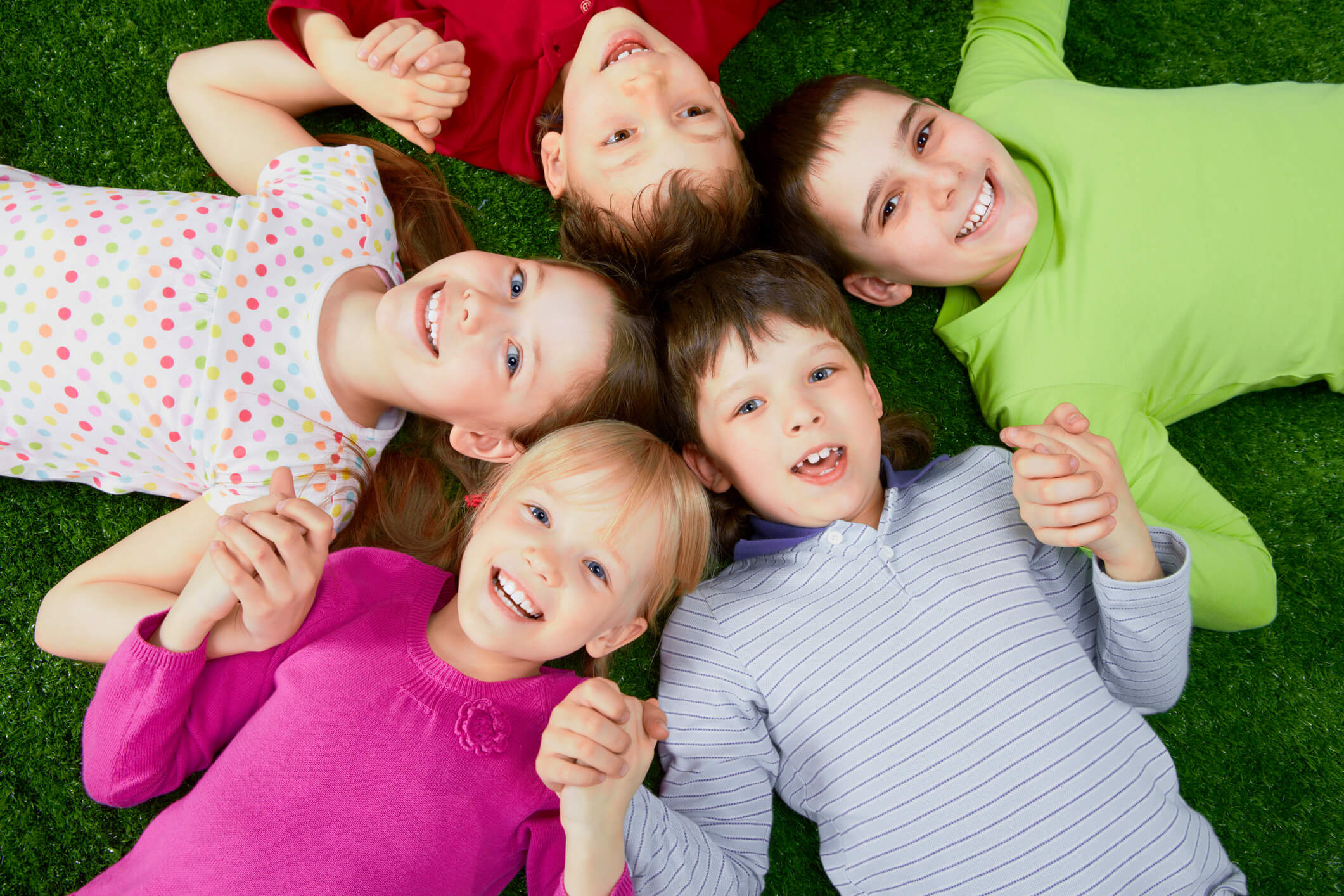 Kids in a circle with their heads attached, holding hands and smiling.